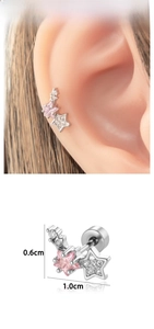 Détail macro du clou d'oreille étoile en acier titane avec zircons roses et clairs