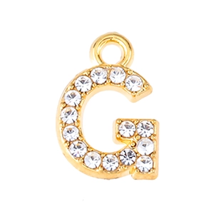 Detail view of a gold-plated letter G pendant featuring sparkling crystal rhinestones