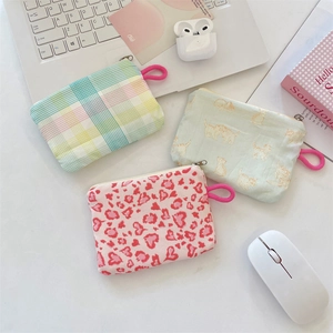 Detailed view of three small floral fabric coin purses with zippers and wrist straps