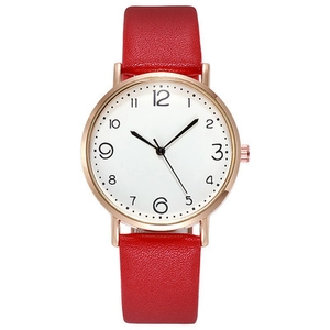Détail d'une montre femme or rose avec bracelet en cuir rouge et cadran blanc