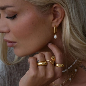 Close-up of model wearing irregular 18K gold plated rings and pearl jewelry