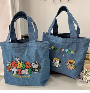 Detail of cartoon bunny and bear embroidery on large denim tote bags for school students