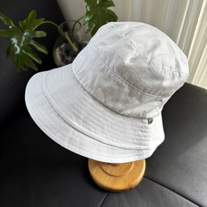 Detail view of cream sun hat with reinforced stitched brim and metal button accent