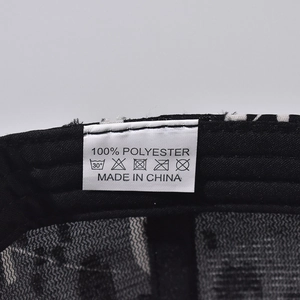 Detail of internal care label on baseball cap showing 100% polyester and washing symbols