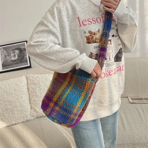 Detail showing the colorful plaid plush crossbody bag with thick lamb wool texture