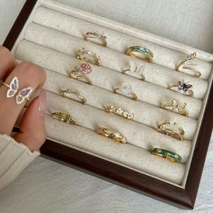 Detailed close-up of 925 sterling silver rings with butterfly and floral motifs in a tray
