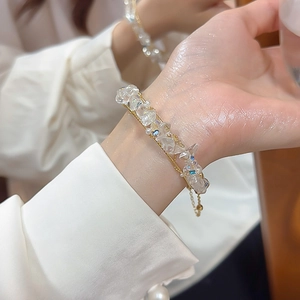 Dettaglio di un bracciale in cristallo vintage francese con perle blu sul polso donna