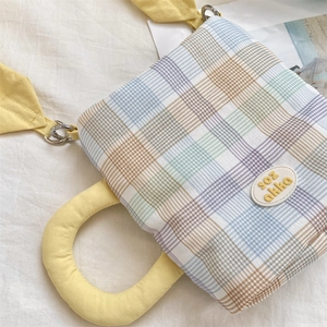 Detail of colorful plaid water bottle bag with bright yellow handles and shoulder strap