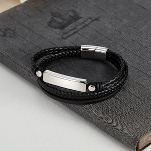 Close-up of black braided leather bracelet for men with polished metal engravable plate