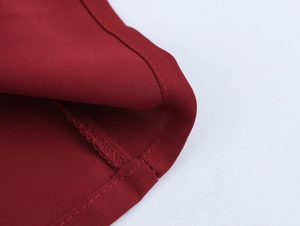 Detail of burgundy tweed fabric texture and precise stitching on a dress collar
