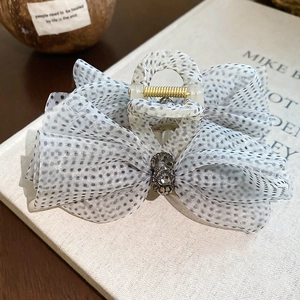 Macro view of mesh bow hair claw with black polka dots and sparkling rhinestones
