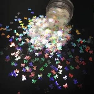 Macro view of iridescent bow-shaped sequins for nail art and DIY resin crafts in a jar