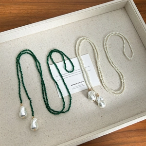 Long pearl and green spinel beaded necklace with irregular pearl pendant on card