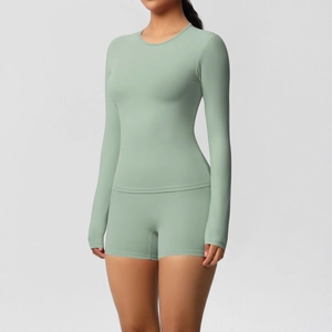 Detail of sage green yoga set showing fitted long sleeve top and athletic shorts