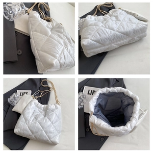Dettaglio della borsa shopper bianca trapuntata con catena dorata e pochette abbinata
