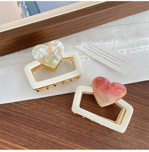 Detail of 6cm heart shark hair clips with marble texture on wood and mesh background