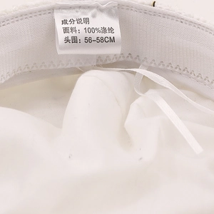 Detail view of newsboy hat inner lining showing 100% polyester label and 56-58cm size