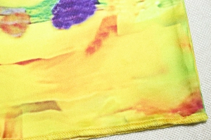 Macro detail of multicolored tie-dye dress fabric featuring fine serger edge stitching