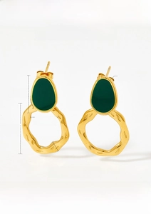 Detail view of vintage gold-plated stainless steel hoop earrings with green oil drip