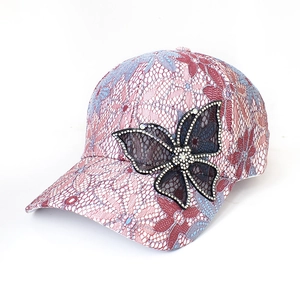 Detail view of lace baseball cap featuring rhinestone butterfly and floral embroidery