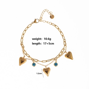 Detailed view of gold double-layer bracelet with heart and evil eye charms and measurements