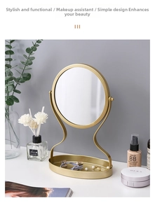 Detail of gold desktop makeup mirror showing circular mirror and oval storage base tray