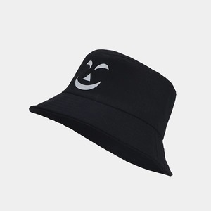 Detalle del estampado de cara de calabaza en el sombrero de pescador negro luminoso