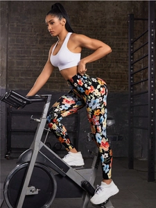 Detailed side view of floral print high-waisted yoga leggings worn in a gym setting