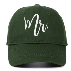 Close-up of dark green cotton baseball cap with white Mr. embroidery and fabric texture