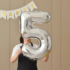 Person holding large silver 40 inch number 5 foil balloon for birthday party decoration