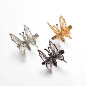Detailed view of hollow butterfly hair clips in gold, silver, and black metallic finishes