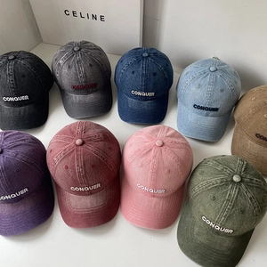 Detail of multi-color washed denim baseball caps with CONQUER embroidery and retro texture
