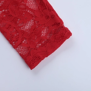 Close-up of red floral lace fabric showing intricate crochet patterns and texture