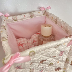 Detailed view of quilted storage basket with pink bow and cute bear cartoon print