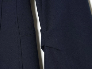 Detailed macro view of navy blue twill fabric texture and clean stitching on the sleeve