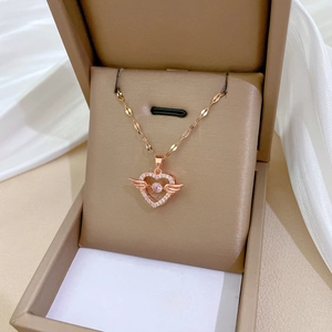Detailed macro shot of a rose gold angel heart necklace with crystals in a jewelry box