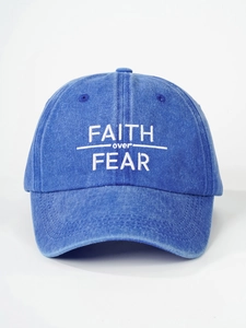 Macro shot of white FAITH OVER FEAR embroidery on blue washed denim baseball cap