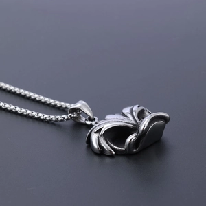 Macro shot of vintage skull mask pendant with box chain in polished stainless steel