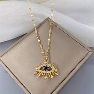 Luxurious gold evil eye necklace with blue and white zircons on a jewelry box