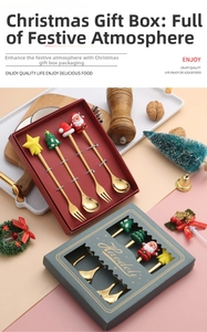 Close-up of golden stainless steel Christmas spoons with festive characters in a gift box