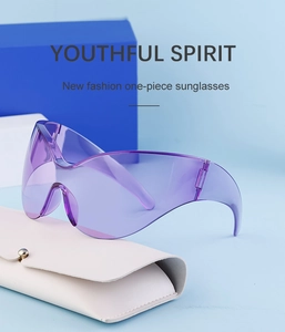 Detail of purple sports sunglasses with translucent shield lens on blue backdrop
