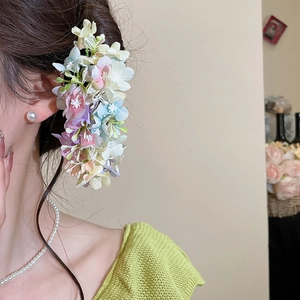 Detail view of multi-colored floral hair pin with realistic pastel fabric hydrangea petals