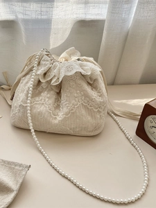 Elegante cremefarbene Spitzen-Beuteltasche mit Blumenstickerei und Perlenkette