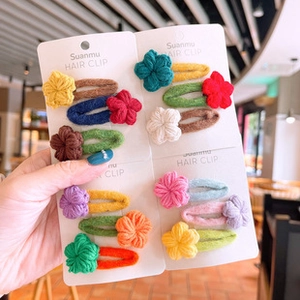 Close-up of colorful knitted flower hair clips set on display cards for girls