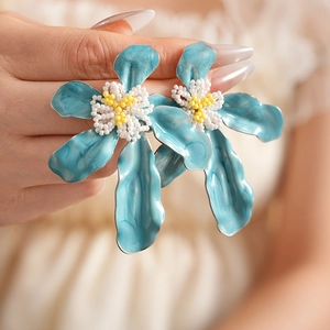Détail des boucles d'oreilles fleurs bleu canard avec pistils perlés à la main