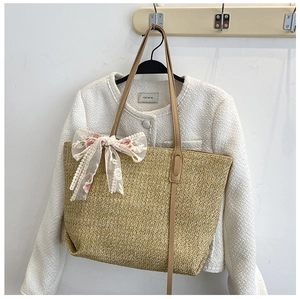 Detailed straw weave texture on a beige tote bag with white floral lace embroidery