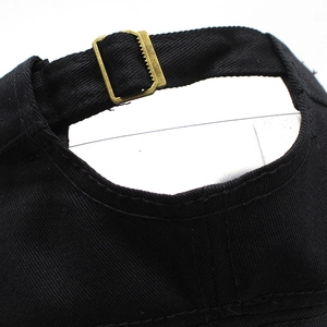 Black cotton baseball cap back detail with adjustable bronze metal buckle and neat stitching