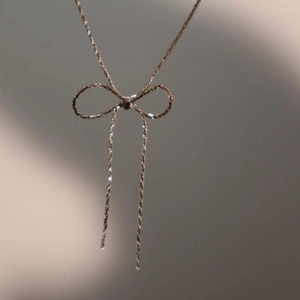 Minimalist gold bow-knot necklace in vintage titanium steel with polished finish