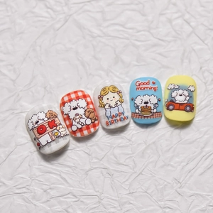 Detailed macro view of cute cartoon dog nail art stickers with Happy Birthday greeting text.