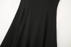 Close-up of black midi dress showing smooth fabric texture and elegant drape details
